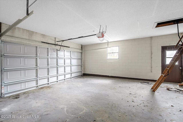 garage with a garage door opener and concrete block wall