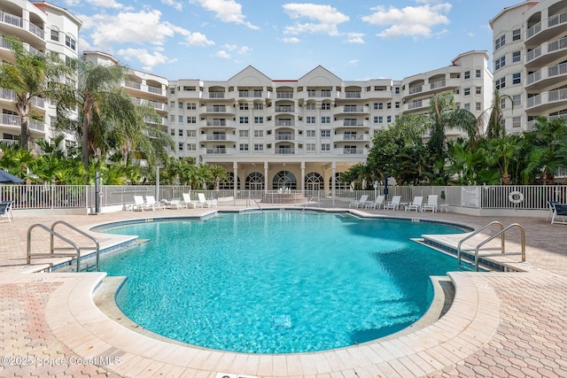 pool with a patio area and fence