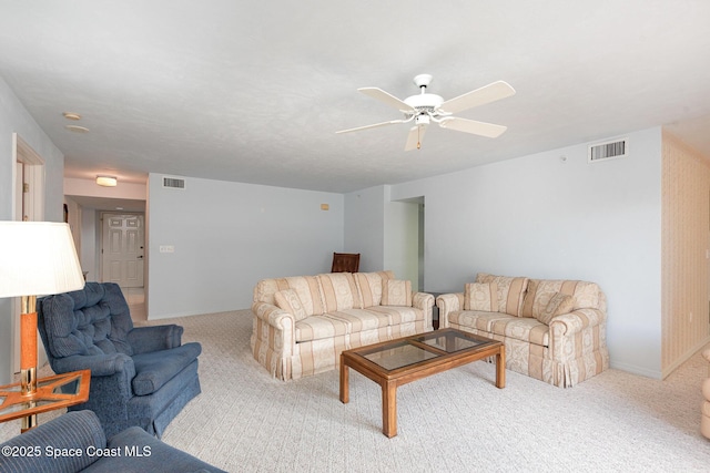 carpeted living room with baseboards, visible vents, and a ceiling fan