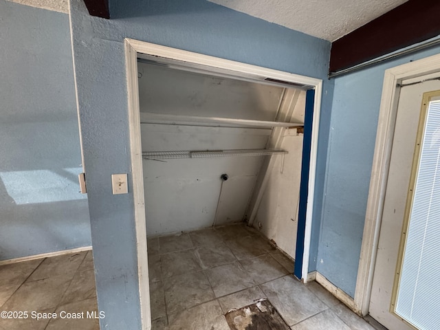 interior space featuring tile patterned flooring and a textured ceiling