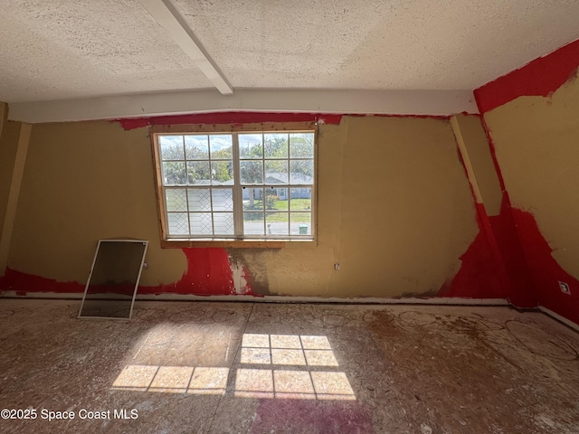 unfurnished room featuring a textured ceiling