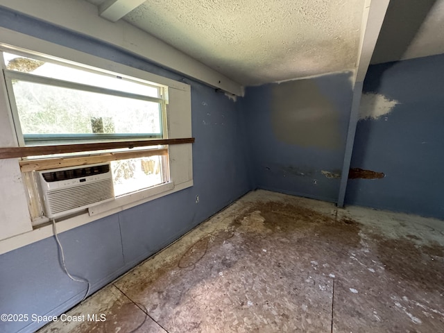 basement featuring a textured ceiling and cooling unit