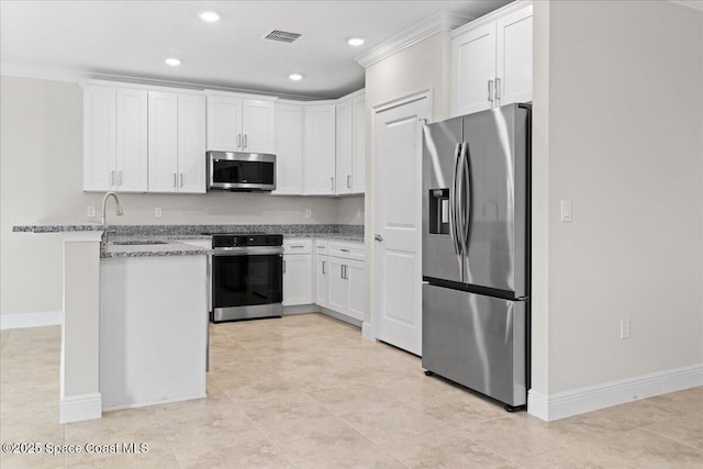 kitchen featuring white cabinets, light stone countertops, stainless steel appliances, and a sink