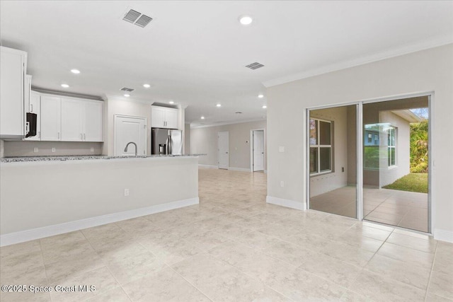 unfurnished living room with baseboards, recessed lighting, visible vents, and crown molding