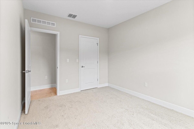 unfurnished bedroom with baseboards, visible vents, and carpet flooring