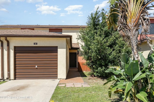 view of front facade with stucco siding, driveway, and an attached garage