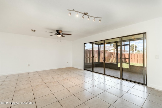 spare room featuring visible vents, baseboards, light tile patterned flooring, and a ceiling fan