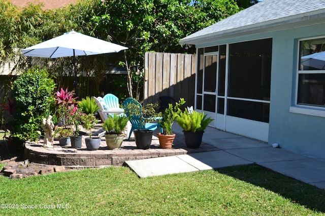 view of yard featuring a patio area, fence, and a sunroom