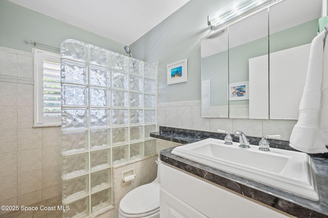 full bathroom with toilet, vanity, walk in shower, and tile walls