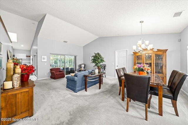 dining space with an inviting chandelier, light colored carpet, visible vents, and lofted ceiling