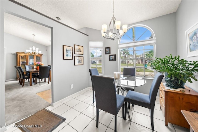 dining area featuring a notable chandelier, light tile patterned floors, and a textured ceiling