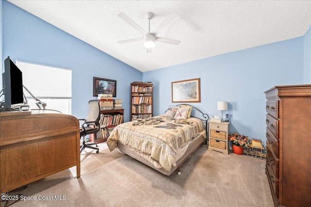 bedroom featuring lofted ceiling, a ceiling fan, carpet floors, and a textured ceiling