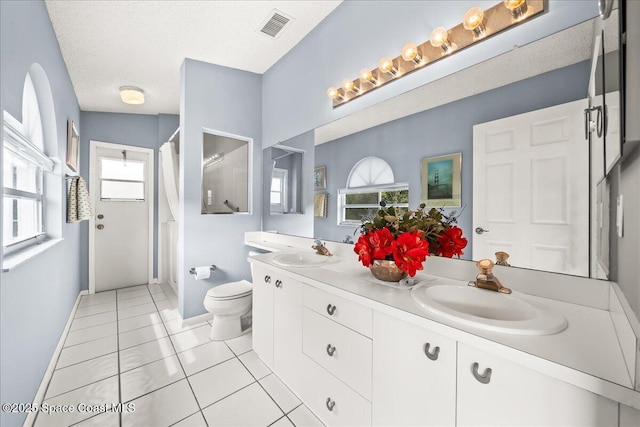 bathroom with a sink, visible vents, toilet, and tile patterned floors