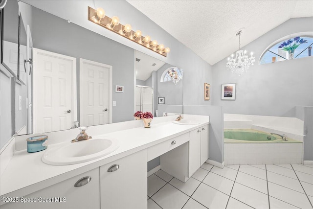 full bathroom featuring a bath, a textured ceiling, lofted ceiling, and a sink