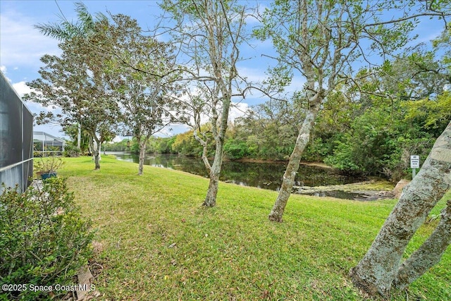 view of yard featuring a water view and a lanai