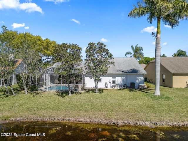 back of house with stucco siding, a lawn, central AC, an outdoor pool, and a lanai