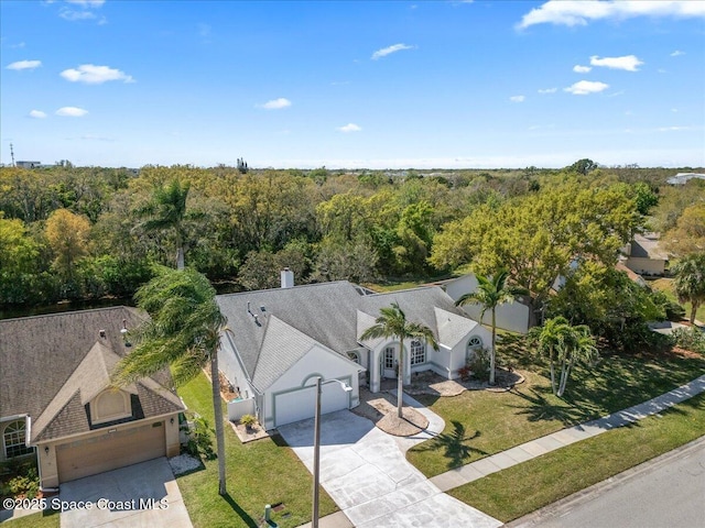 birds eye view of property with a view of trees