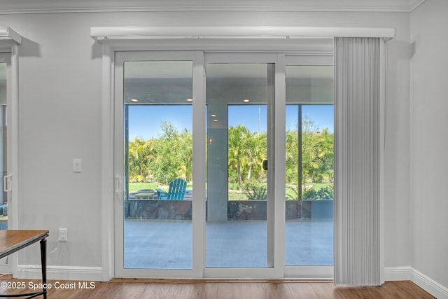 doorway to outside featuring wood finished floors and baseboards