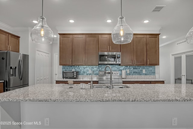 kitchen featuring visible vents, crown molding, appliances with stainless steel finishes, and a sink