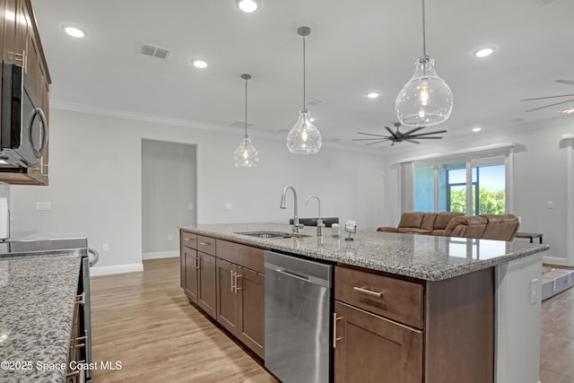 kitchen with appliances with stainless steel finishes, a sink, and ornamental molding