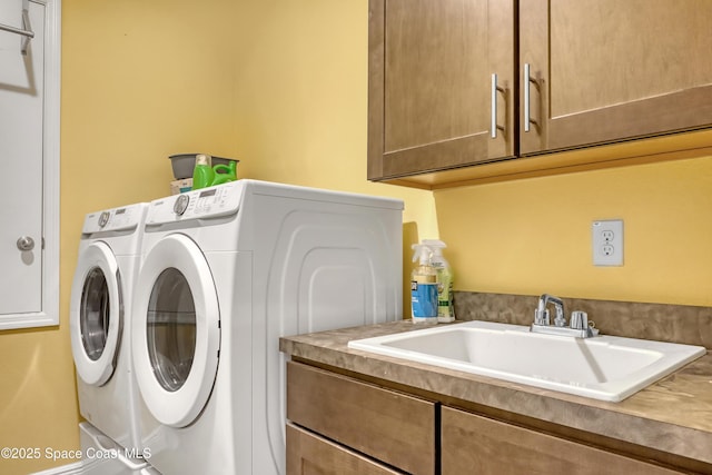 laundry area with a sink, cabinet space, and washer and dryer