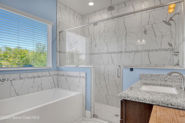 bathroom featuring a stall shower, marble finish floor, a garden tub, and vanity