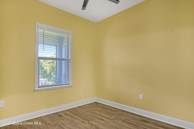 unfurnished room featuring wood finished floors, a ceiling fan, and baseboards