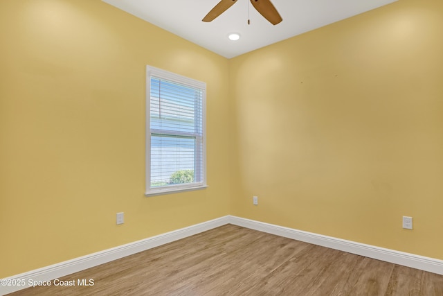 unfurnished room with ceiling fan, wood finished floors, and baseboards