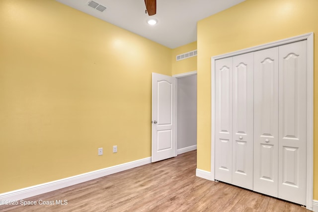 unfurnished bedroom featuring a closet, baseboards, visible vents, and light wood finished floors