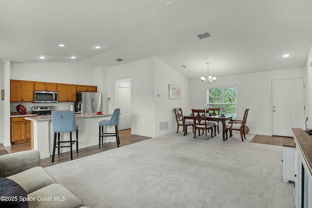 living area with lofted ceiling, light carpet, visible vents, and recessed lighting