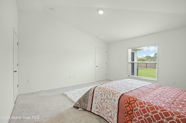 carpeted bedroom featuring lofted ceiling and baseboards