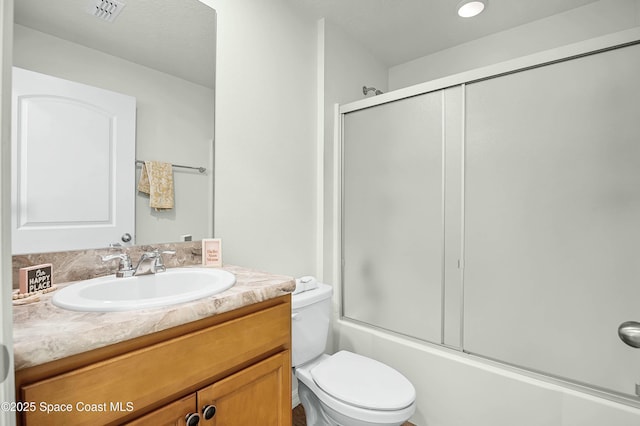 bathroom featuring toilet, shower / bath combination with glass door, vanity, and visible vents