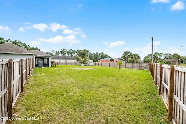 view of yard featuring a fenced backyard and central AC