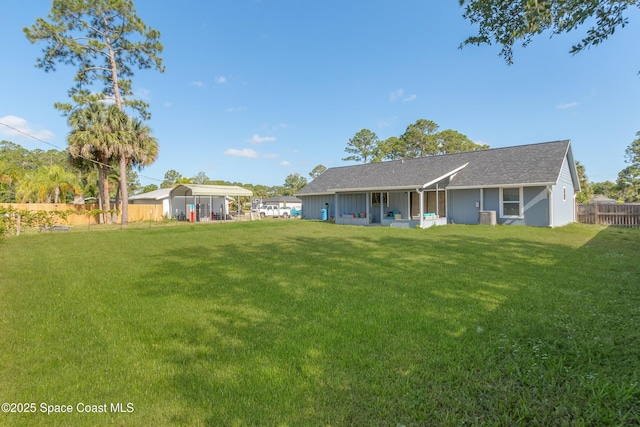 back of property with central AC, a lawn, and fence