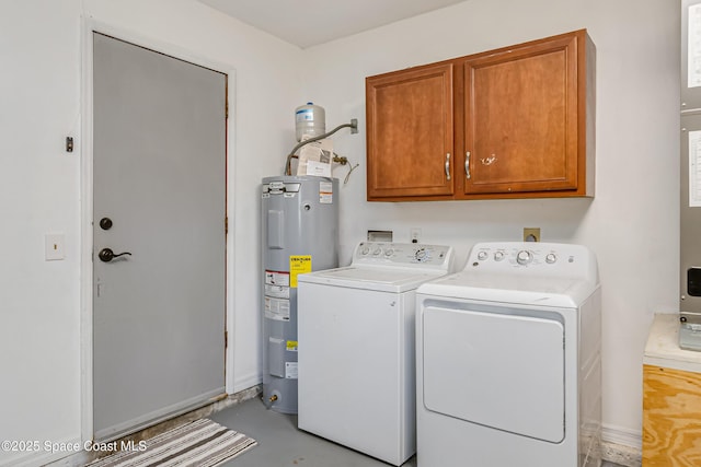 washroom with water heater, washing machine and dryer, and cabinet space