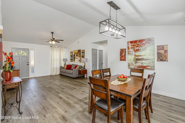 dining space with lofted ceiling, ceiling fan, light wood-type flooring, and baseboards