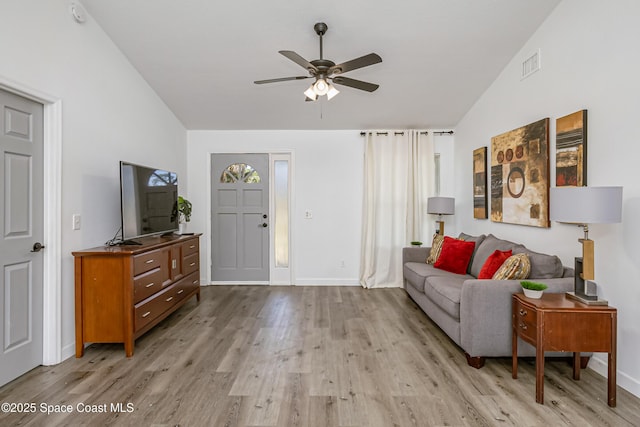 living room featuring visible vents, light wood-style flooring, vaulted ceiling, ceiling fan, and baseboards