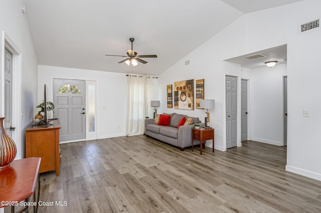 foyer entrance featuring baseboards, visible vents, ceiling fan, wood finished floors, and vaulted ceiling