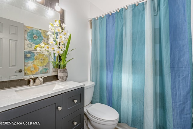 full bath featuring toilet, curtained shower, and vanity