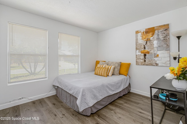 bedroom with wood finished floors and baseboards