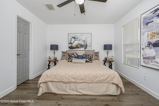 bedroom featuring ceiling fan, wood finished floors, visible vents, and baseboards