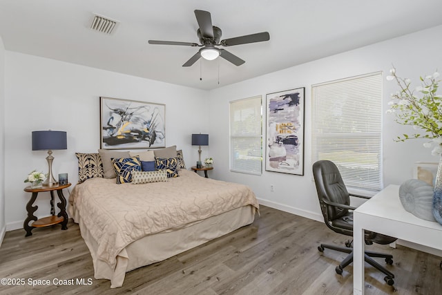 bedroom with multiple windows, wood finished floors, and visible vents