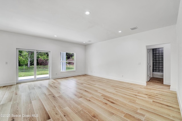 unfurnished room featuring baseboards, visible vents, light wood-style flooring, and recessed lighting