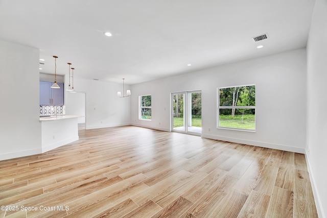 unfurnished living room with light wood-style floors, baseboards, visible vents, and recessed lighting