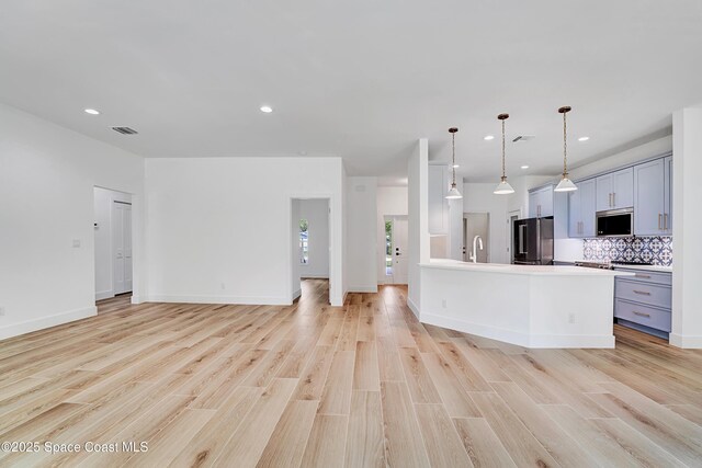 kitchen with tasteful backsplash, gray cabinets, visible vents, light wood-style flooring, and appliances with stainless steel finishes