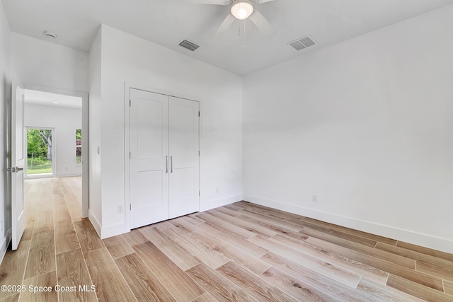 unfurnished bedroom featuring light wood-type flooring, baseboards, and visible vents