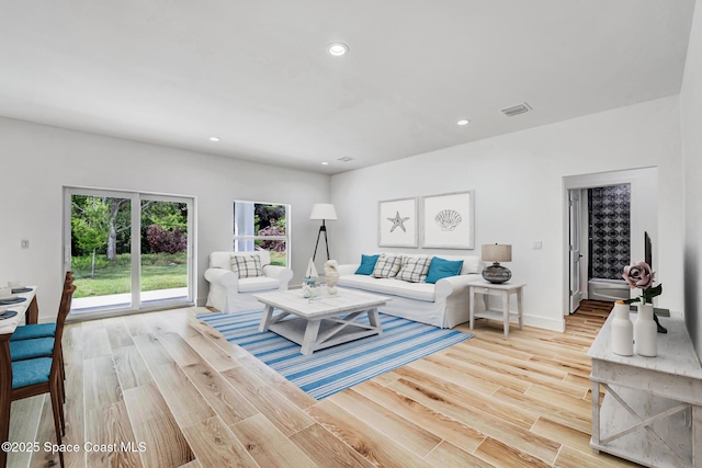 living area with light wood-type flooring, baseboards, visible vents, and recessed lighting