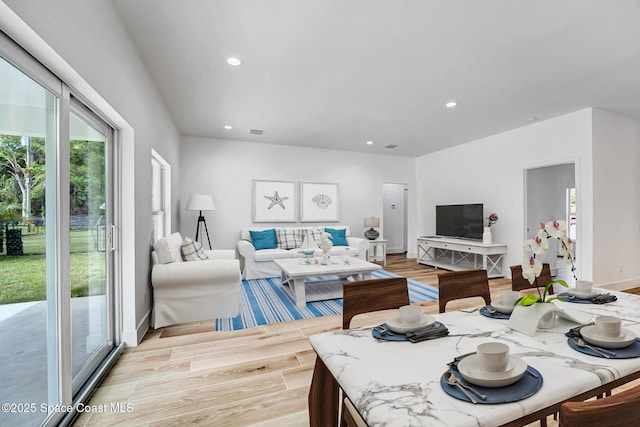 living area with light wood-style floors, recessed lighting, visible vents, and baseboards