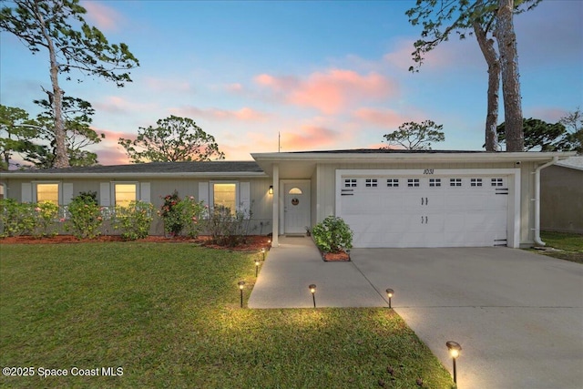 single story home with a garage, concrete driveway, and a front yard