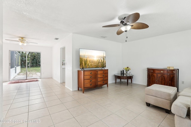 sitting room with a ceiling fan, light tile patterned flooring, and visible vents